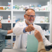 Pharmacien effectuant son travail en officine pouvant être atteint par des mots de dos