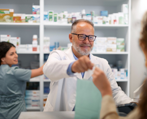 Pharmacien effectuant son travail en officine pouvant être atteint par des mots de dos