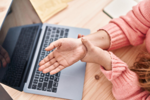 Une employée se rend compte qu'elle a mal au poignet, peut-être le début d'un TMS
